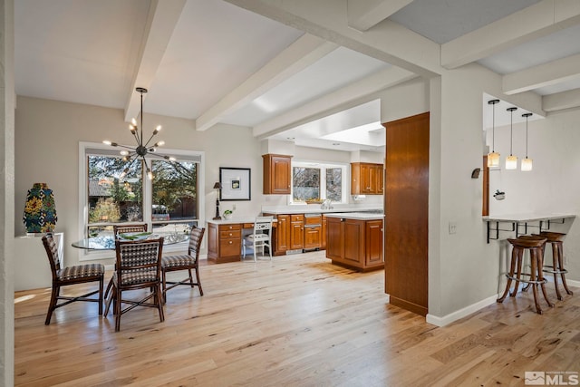 dining area with a notable chandelier, beam ceiling, and light hardwood / wood-style flooring