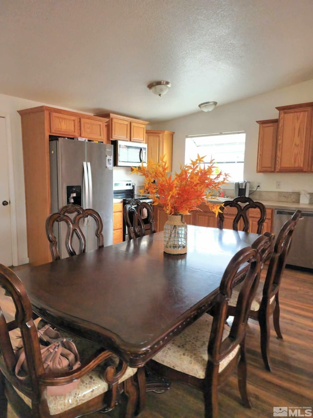 dining area featuring dark hardwood / wood-style floors and a textured ceiling