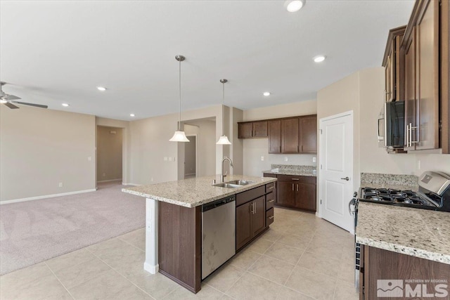 kitchen with sink, decorative light fixtures, an island with sink, light colored carpet, and stainless steel appliances