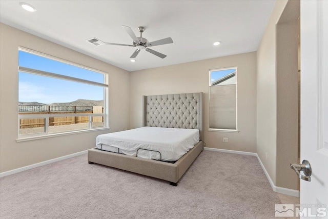 carpeted bedroom with multiple windows and ceiling fan