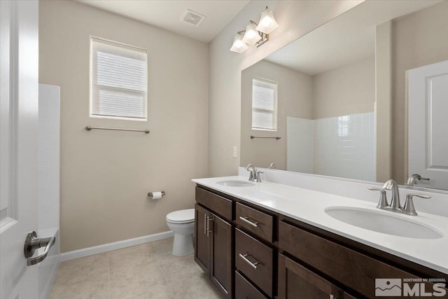 bathroom featuring vanity, a shower, tile patterned floors, and toilet