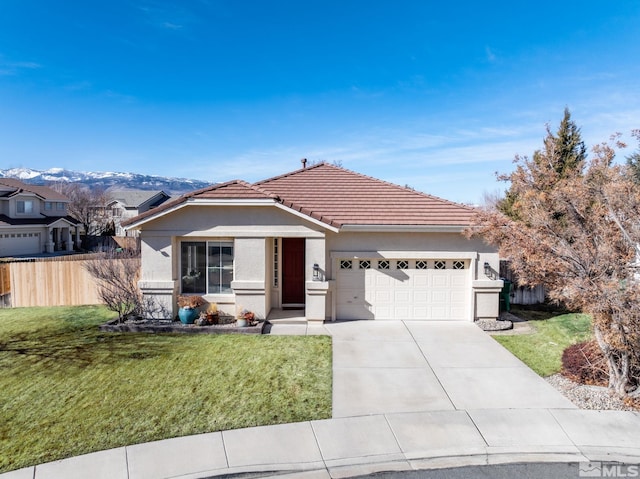 ranch-style house featuring a mountain view, a garage, and a front lawn