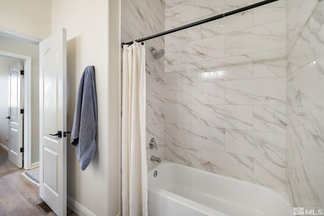 bathroom featuring hardwood / wood-style flooring and shower / bath combo with shower curtain