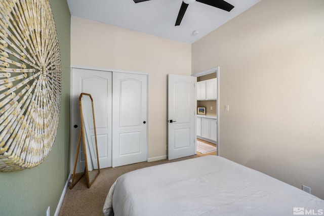 bedroom with light colored carpet, ceiling fan, and a closet