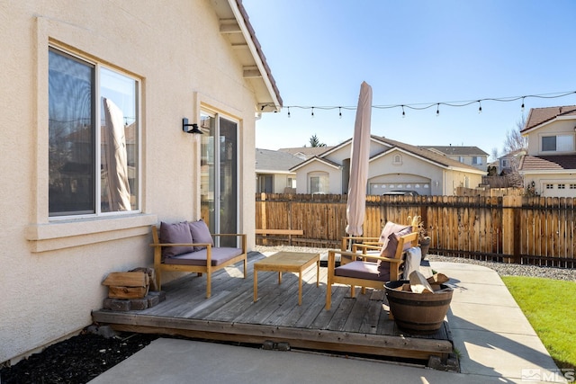 wooden terrace with an outdoor hangout area and a patio area