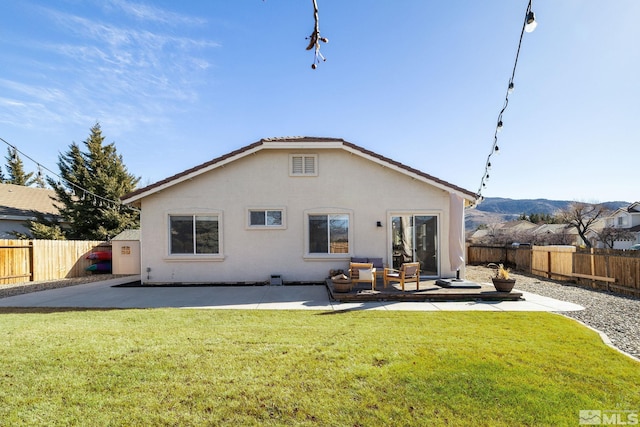 rear view of property featuring a patio area and a lawn