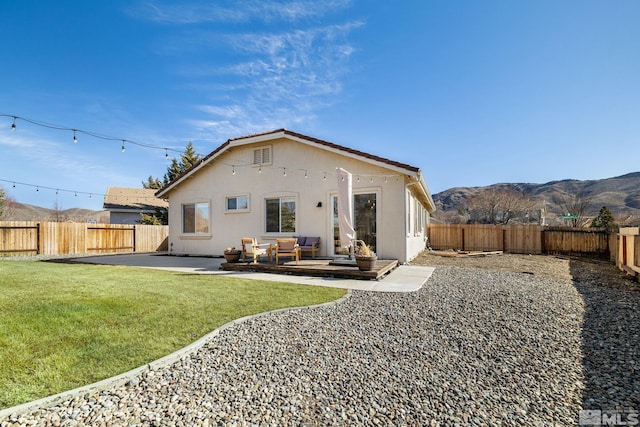 back of house featuring a yard, a mountain view, and a patio