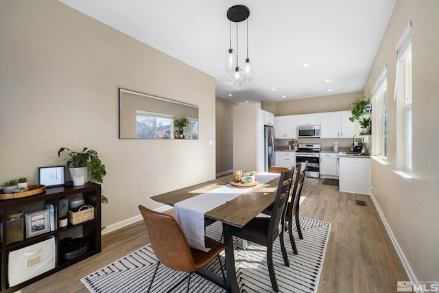 dining room with light hardwood / wood-style floors and sink