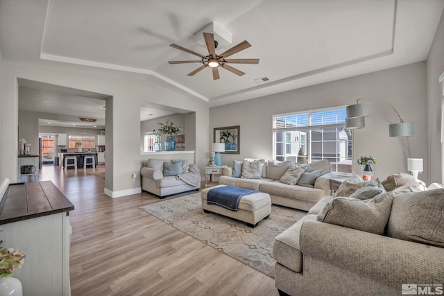 living room with vaulted ceiling, light hardwood / wood-style floors, and ceiling fan