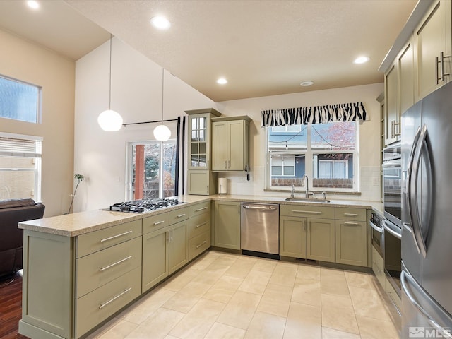 kitchen featuring sink, plenty of natural light, pendant lighting, stainless steel appliances, and backsplash