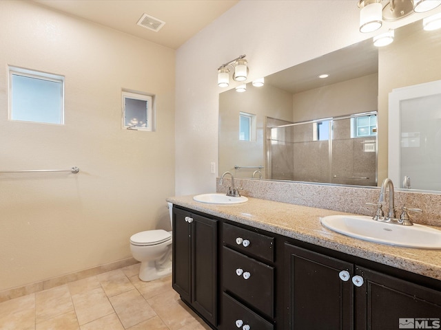 bathroom with tile patterned flooring, vanity, a shower with door, and toilet