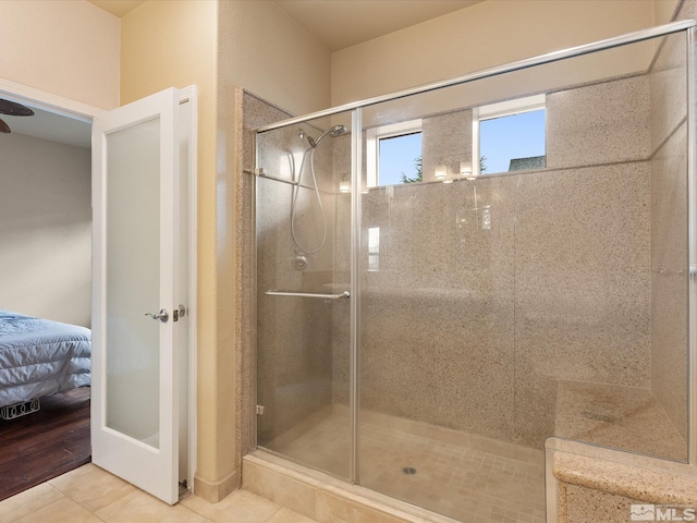 bathroom with a shower with door and tile patterned floors