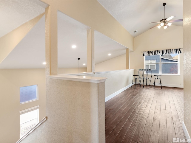 hall with dark wood-type flooring and vaulted ceiling