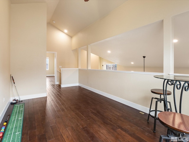 interior space featuring vaulted ceiling and dark wood-type flooring