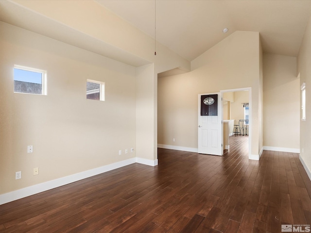 unfurnished living room with dark wood-type flooring and high vaulted ceiling