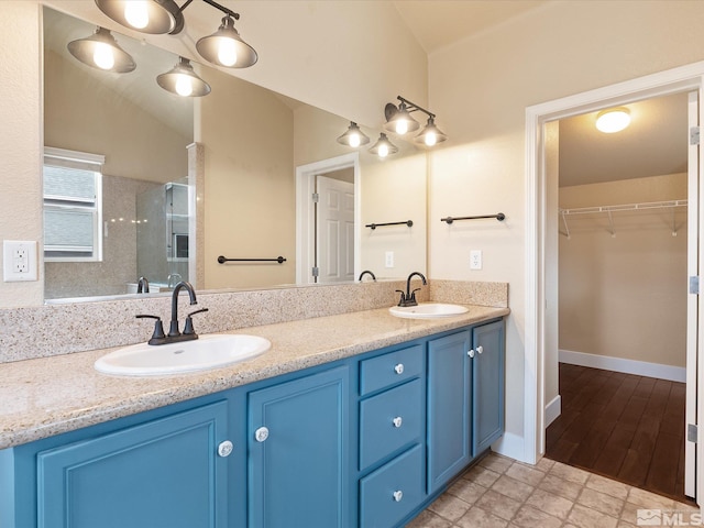 bathroom with vanity, a shower with shower door, and vaulted ceiling