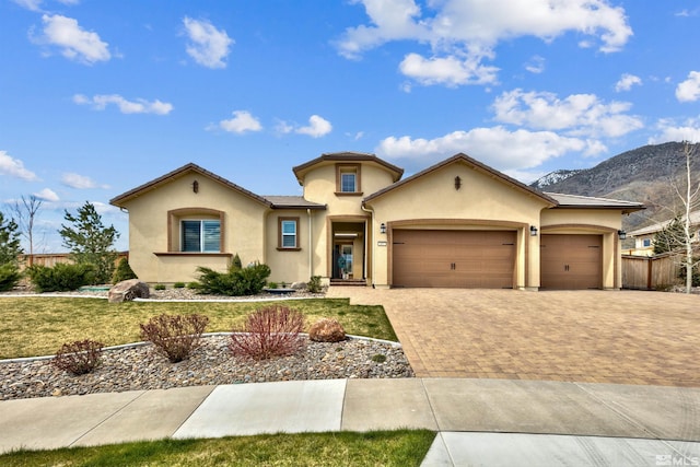 view of front of home with a mountain view, a garage, and a front yard