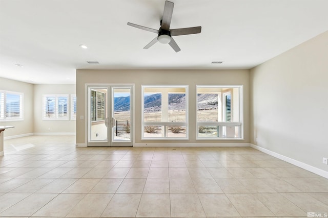 tiled spare room with ceiling fan