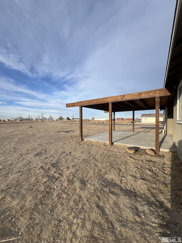 view of yard with a rural view and a patio area