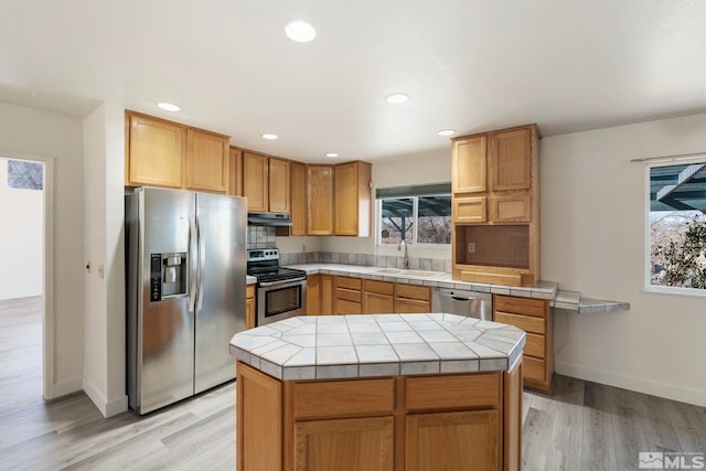 kitchen with a kitchen island, sink, tile countertops, and appliances with stainless steel finishes
