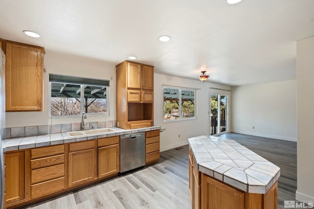 kitchen featuring light hardwood / wood-style flooring, sink, tile counters, and dishwasher