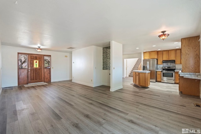 kitchen featuring stainless steel appliances, a center island, and light hardwood / wood-style floors