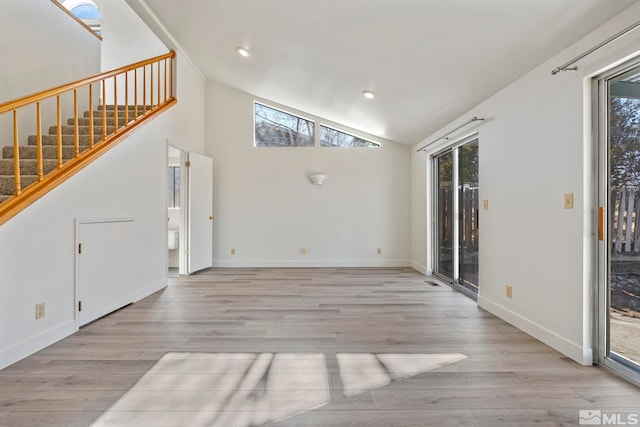 unfurnished living room with high vaulted ceiling and light hardwood / wood-style floors
