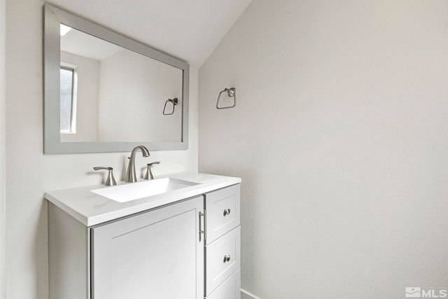 bathroom with vanity and lofted ceiling