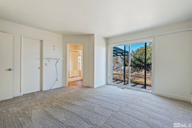 unfurnished bedroom with carpet, connected bathroom, and access to exterior