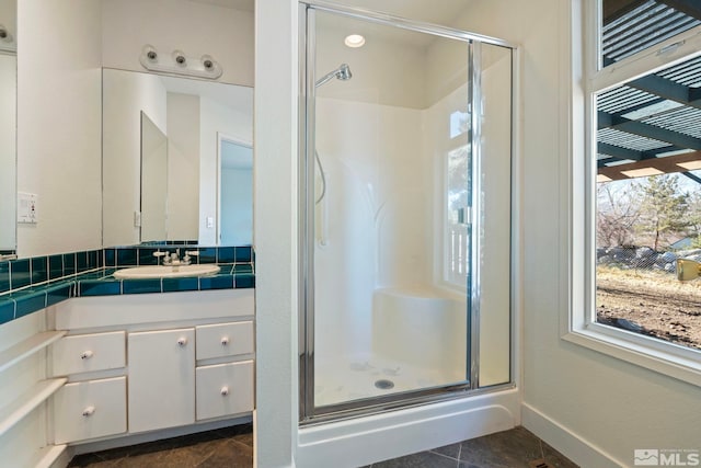 bathroom featuring a shower with door, vanity, and tile patterned flooring