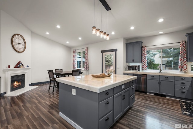 kitchen with gray cabinets, a kitchen island, black dishwasher, sink, and hanging light fixtures