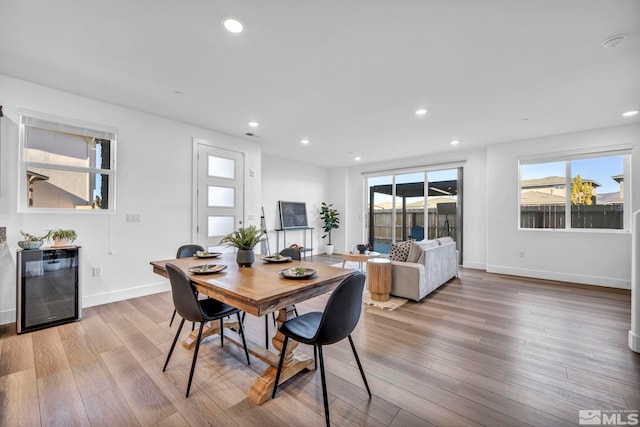 dining room with wine cooler, recessed lighting, and wood finished floors