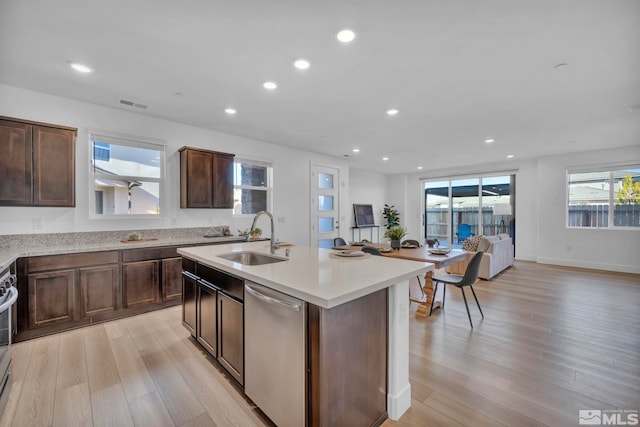 kitchen featuring light wood-style flooring, recessed lighting, stainless steel appliances, a sink, and light countertops