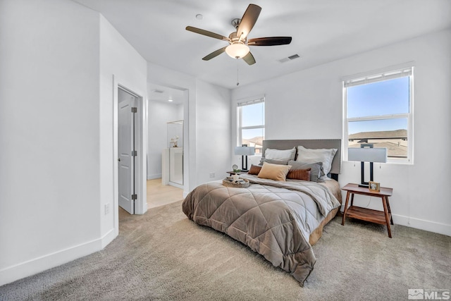 carpeted bedroom featuring a ceiling fan, visible vents, and baseboards