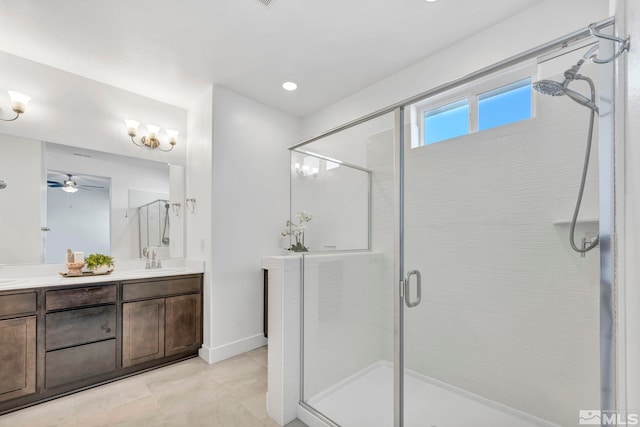 bathroom with double vanity, baseboards, tile patterned flooring, a shower stall, and a sink