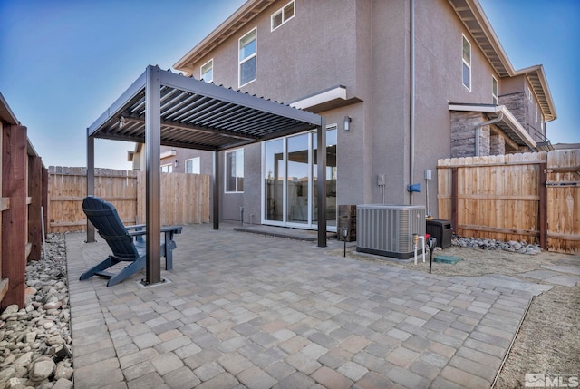 rear view of house with a fenced backyard, cooling unit, stucco siding, a pergola, and a patio area