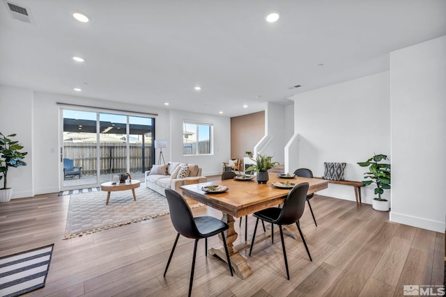 dining area with baseboards, light wood finished floors, visible vents, and recessed lighting