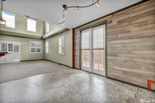 interior space with french doors, light carpet, and a high ceiling