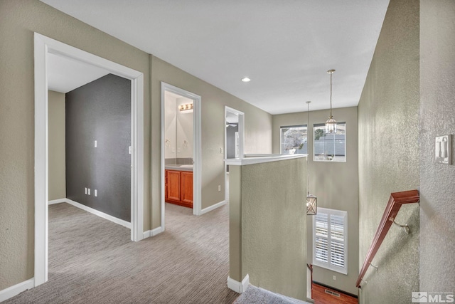 hallway featuring light colored carpet