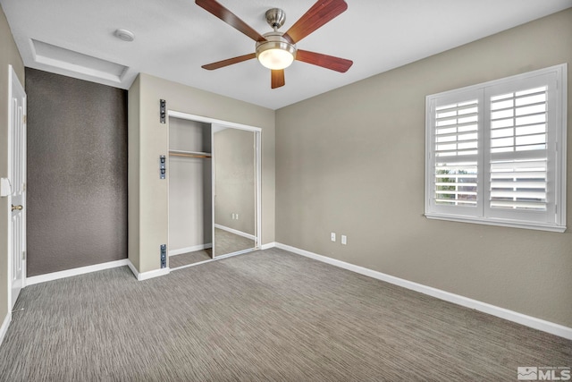 unfurnished bedroom featuring carpet floors, ceiling fan, and a closet