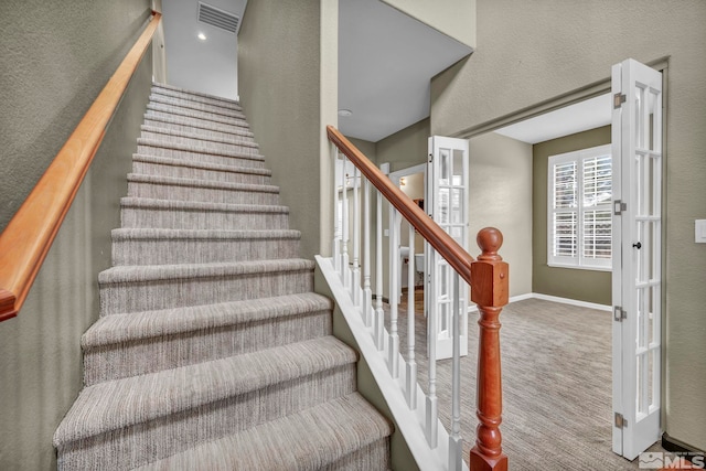 staircase featuring carpet