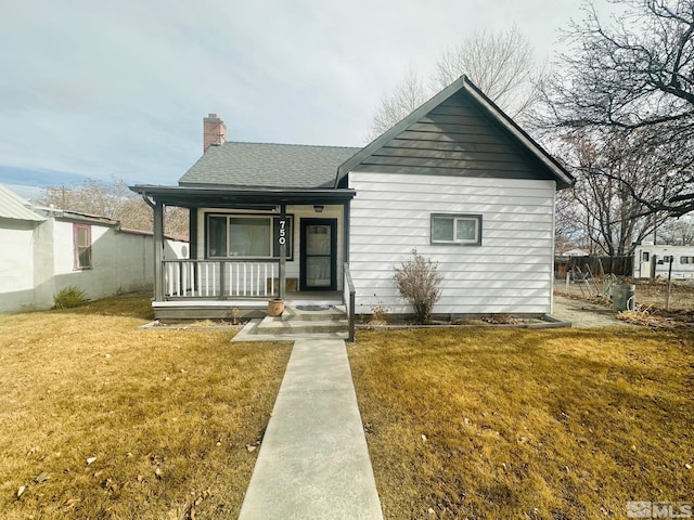 bungalow-style home featuring covered porch and a front yard