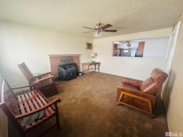 sitting room featuring dark colored carpet, ceiling fan, a textured ceiling, and a wood stove