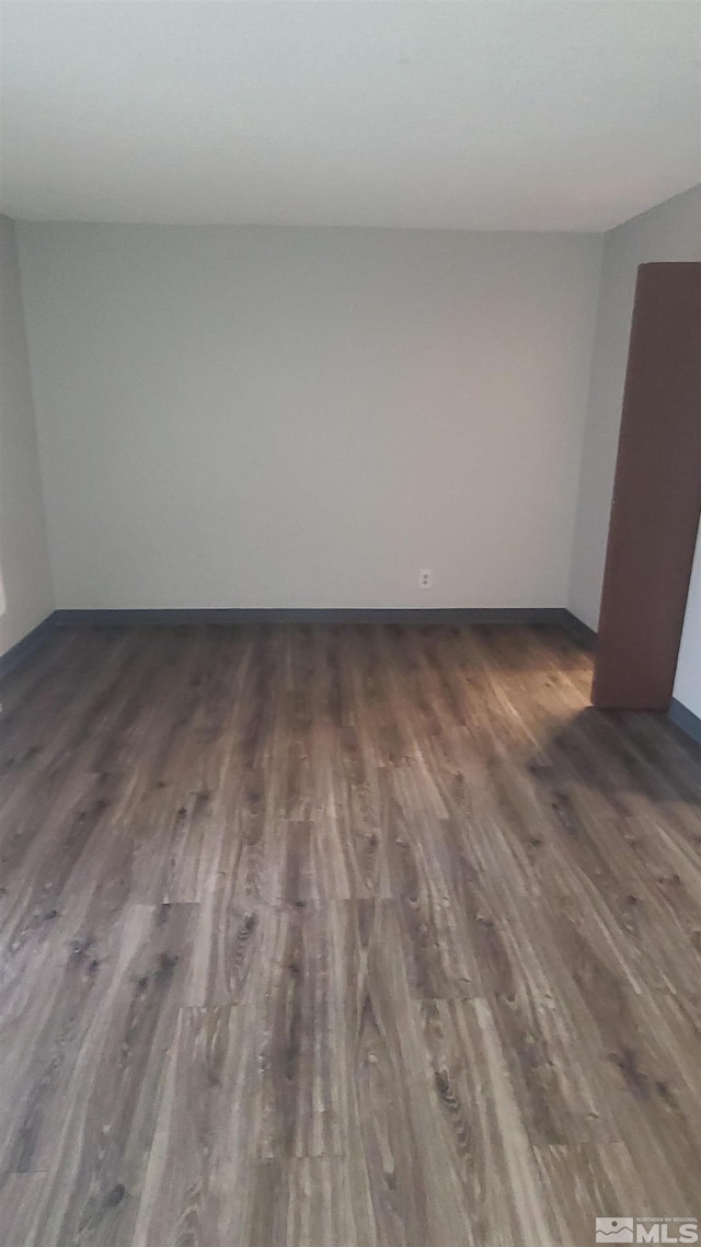 spare room with dark wood-type flooring