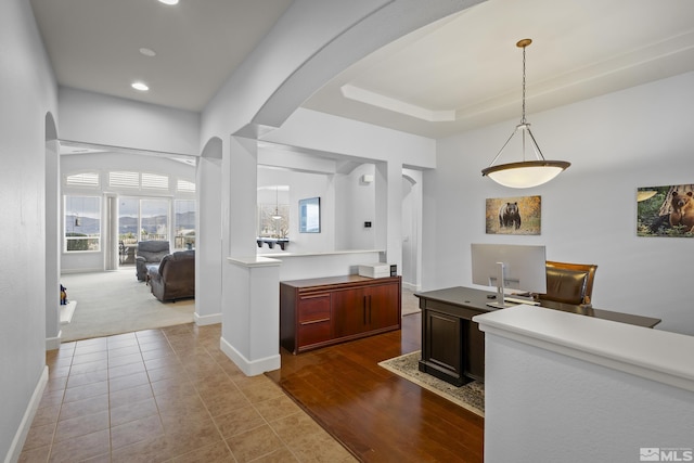 kitchen featuring a tray ceiling, decorative light fixtures, and light tile patterned floors