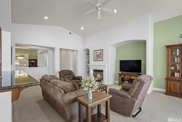 carpeted living room featuring ceiling fan, vaulted ceiling, and built in features