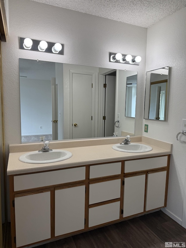 bathroom with vanity, hardwood / wood-style floors, and a textured ceiling