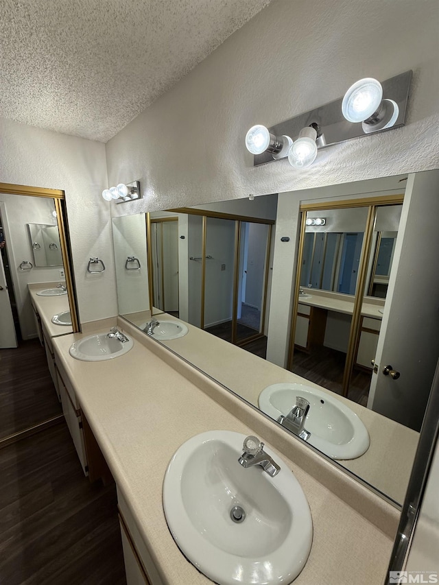 bathroom featuring vanity, wood-type flooring, and a textured ceiling