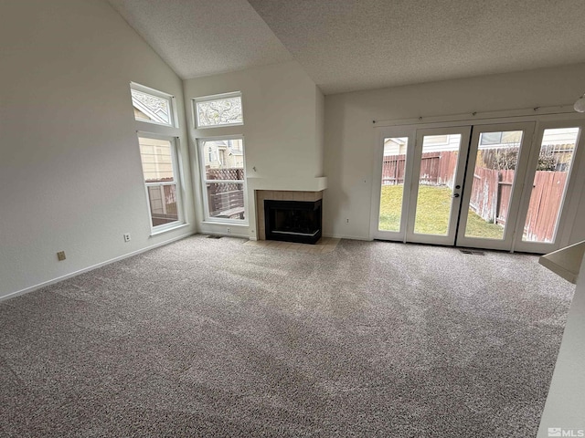 unfurnished living room featuring a fireplace, high vaulted ceiling, a textured ceiling, and carpet