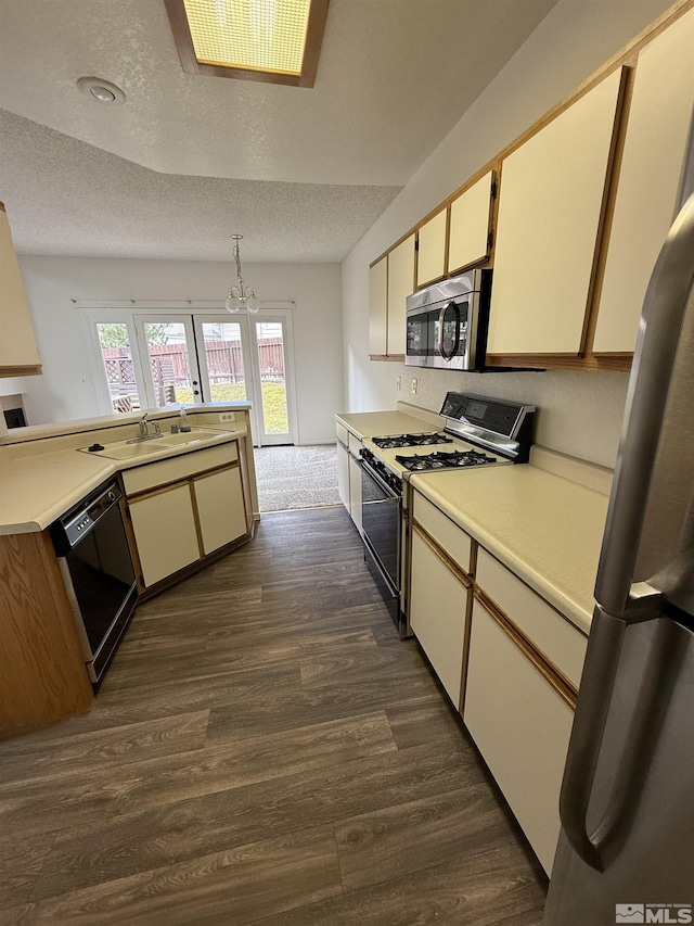 kitchen featuring sink, a textured ceiling, appliances with stainless steel finishes, dark hardwood / wood-style flooring, and a notable chandelier